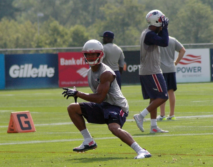 an american football player catching the ball while others watch