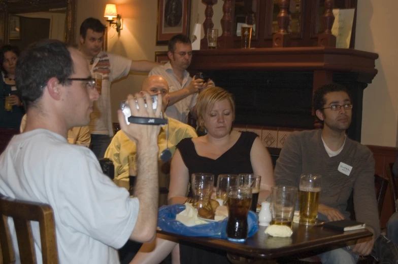 group of people sitting around eating and drinking in front of them