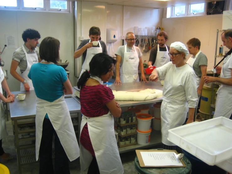 a group of people standing in a kitchen preparing food