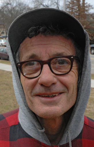 a man wearing glasses, a hoodie and a hat