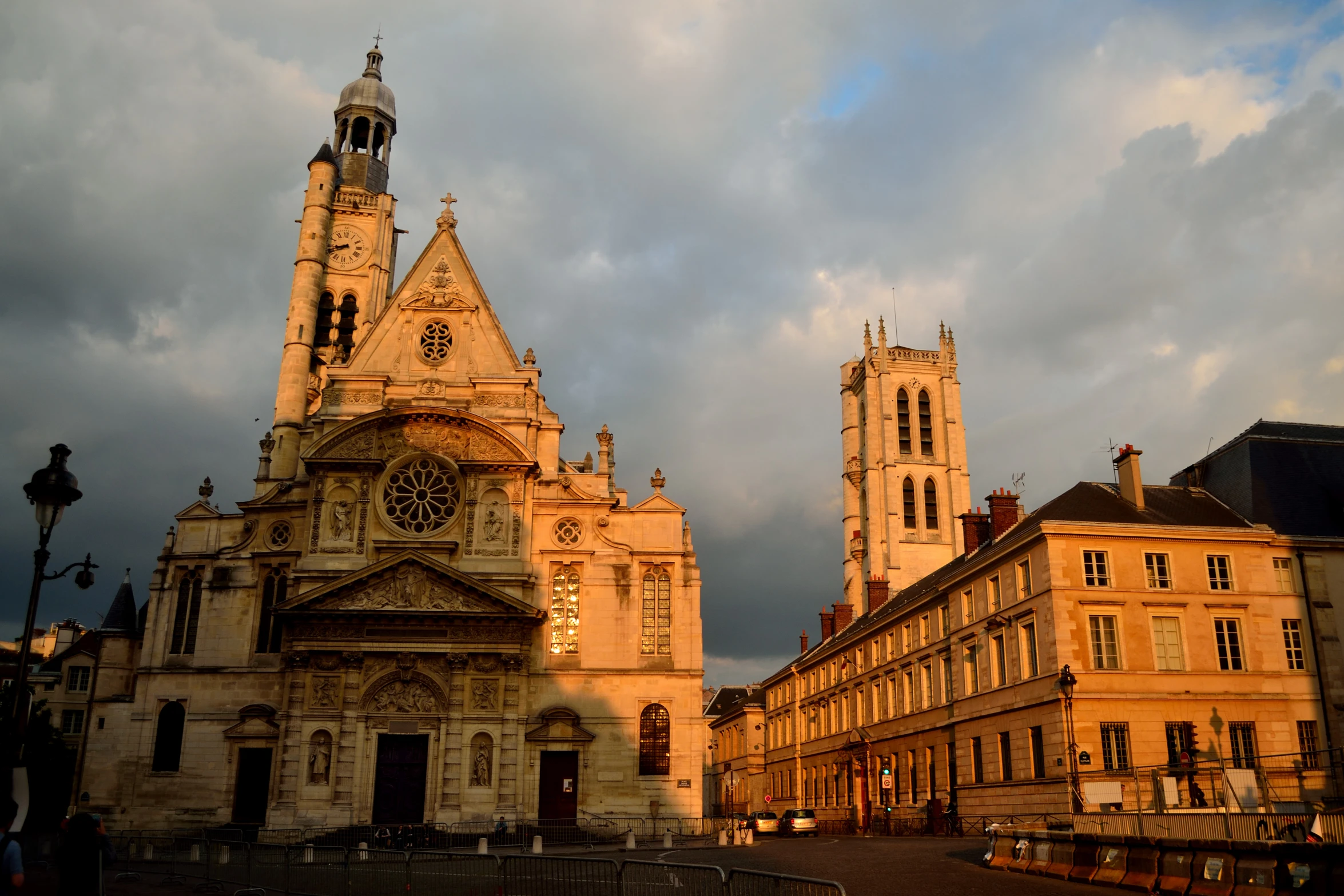 several buildings with one clock in the center and another behind