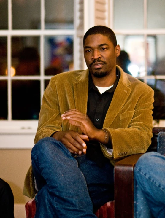 a man is sitting in front of a window in a house