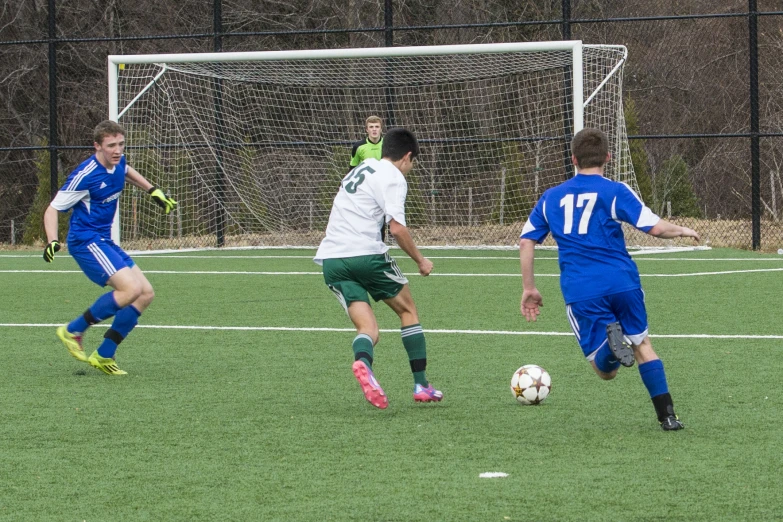 some s in uniform are playing soccer on the field