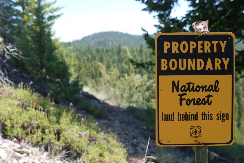 a warning sign on the edge of a grassy hill