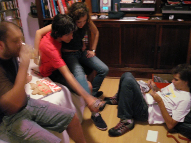 a group of people sitting and standing around a living room