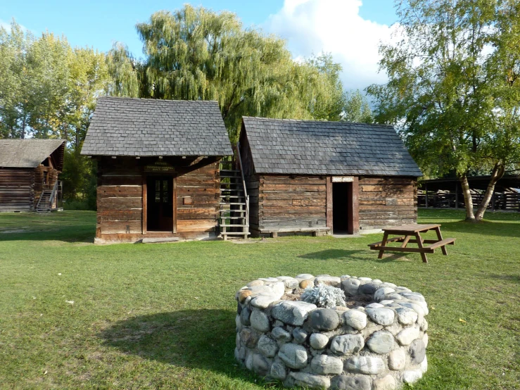 a row of rustic log cabins are in a field