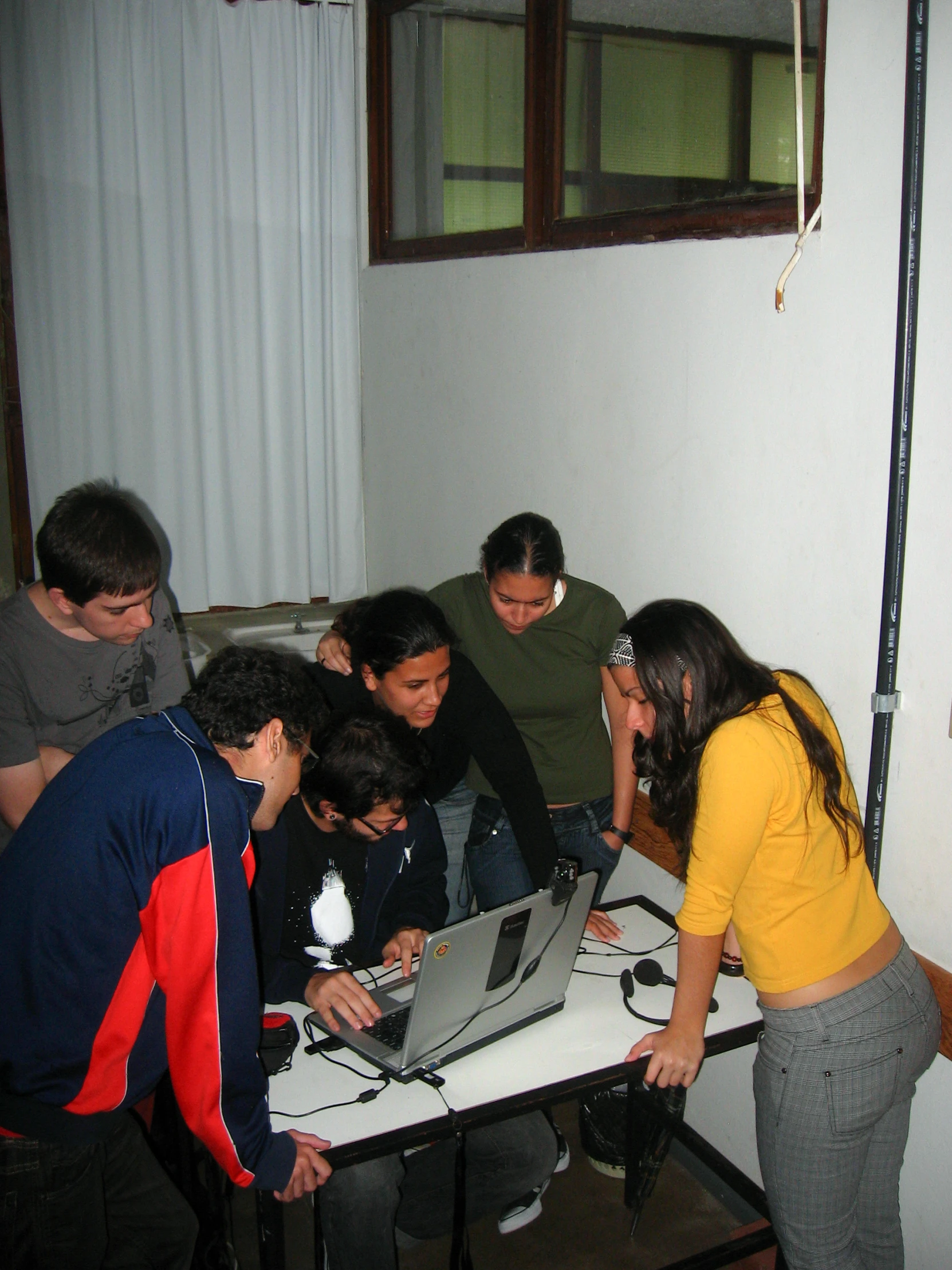 people looking at a computer screen together with others