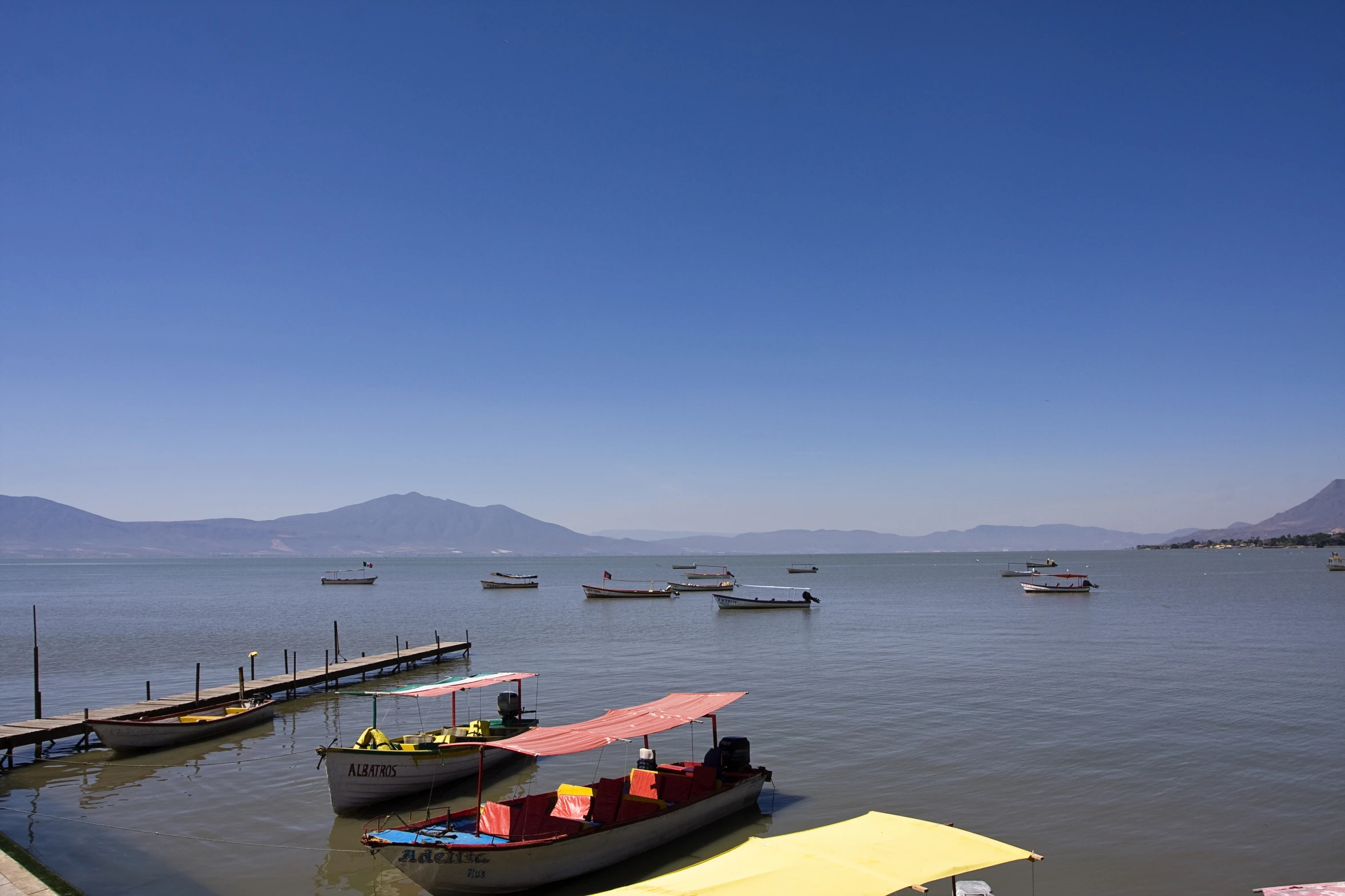 boats at the end of a long pier