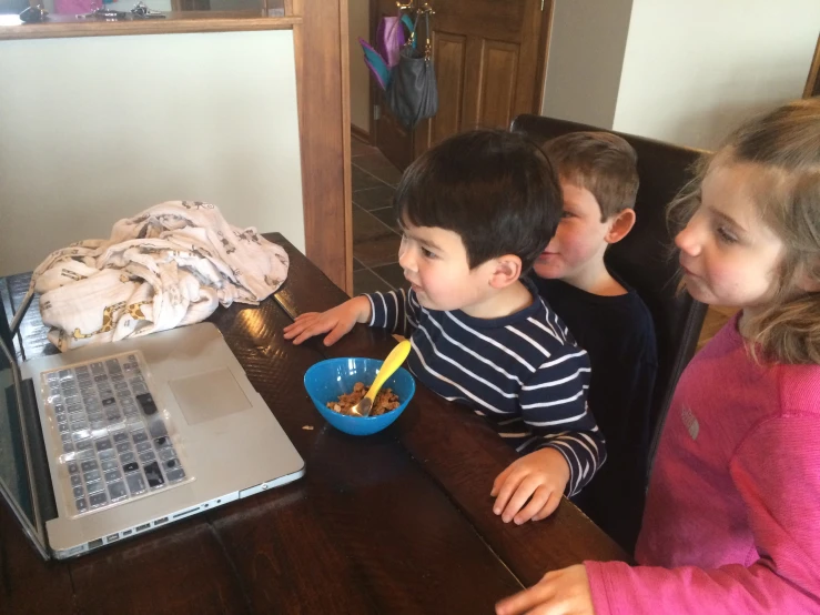 three s sit at the table with their laptop