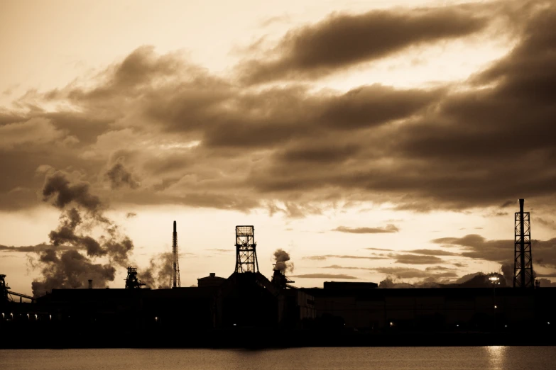 the smokestacks of a factory are visible from across the water
