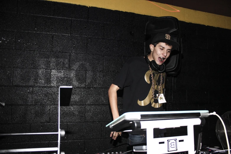 a person wearing a hat standing at a stage with a mixer