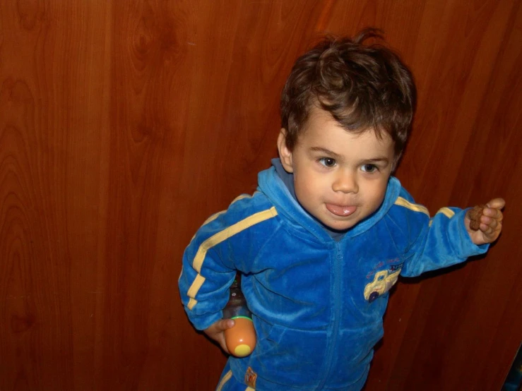 a small child in blue jacket holding an apple