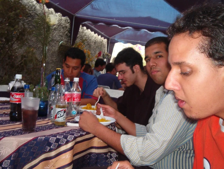 the group is eating at the table with drinks