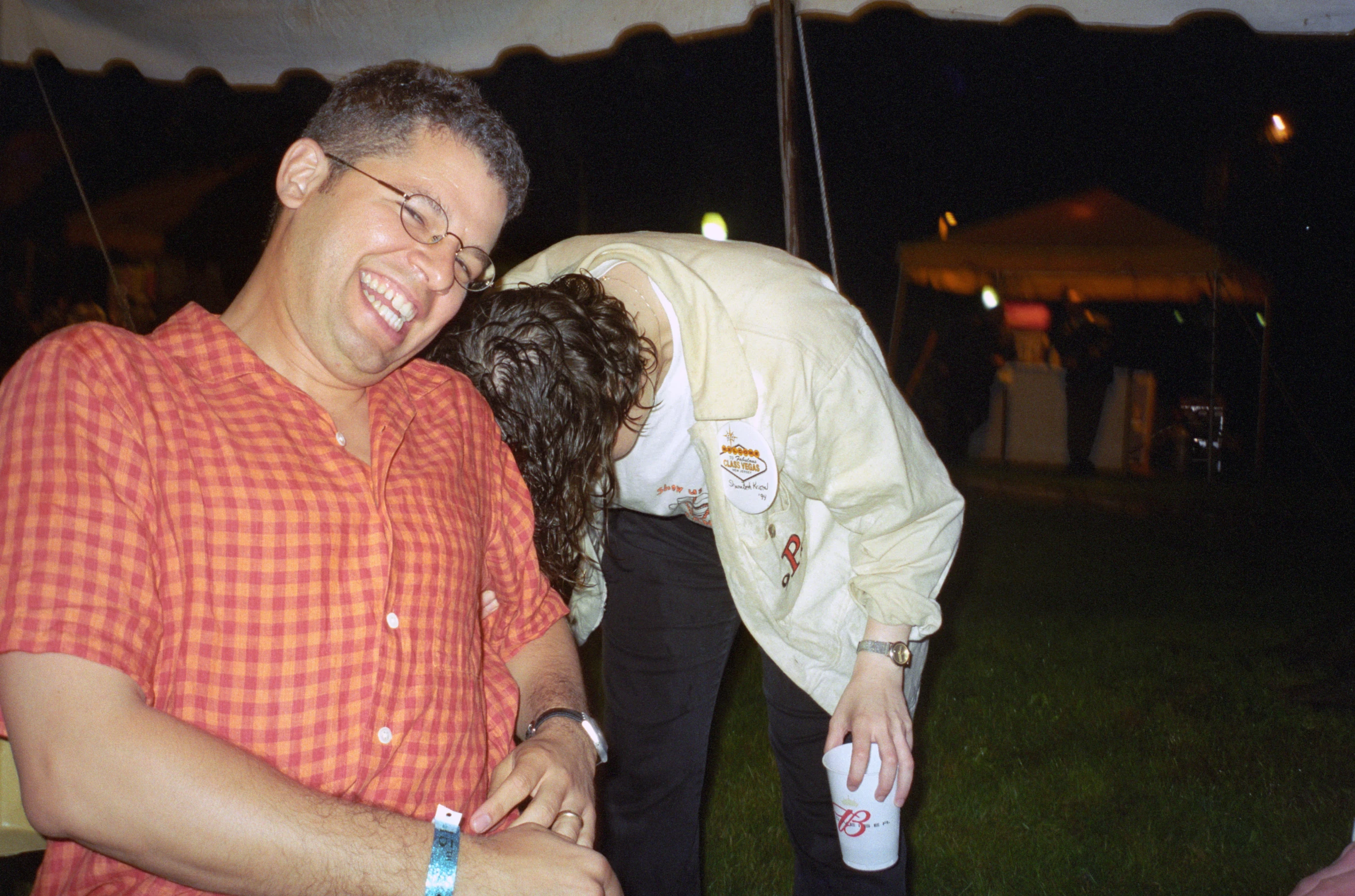 a couple with water bottles hug in a field