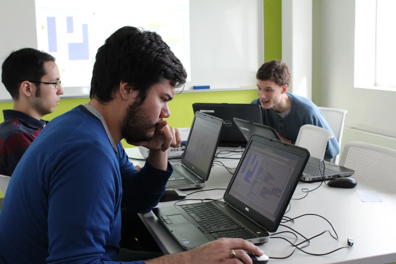 a group of guys in a room with laptops