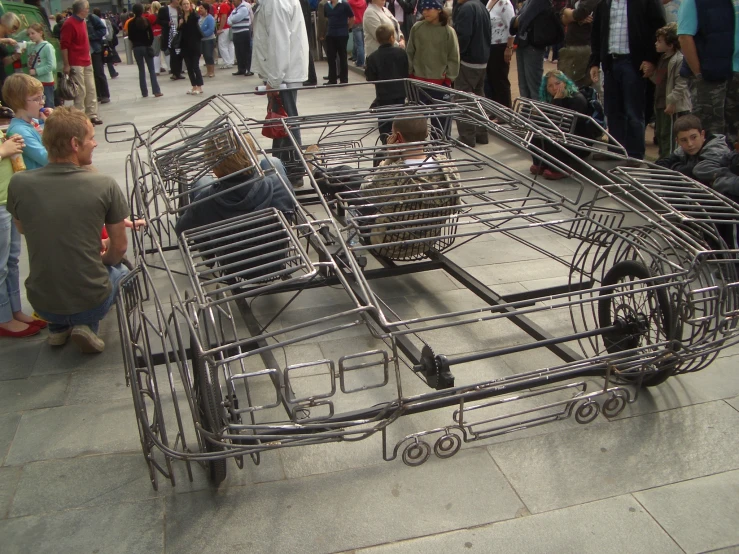 an elaborate metal caged carriage on a sidewalk