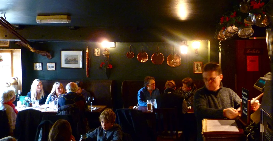 there is a large group of people sitting at tables eating