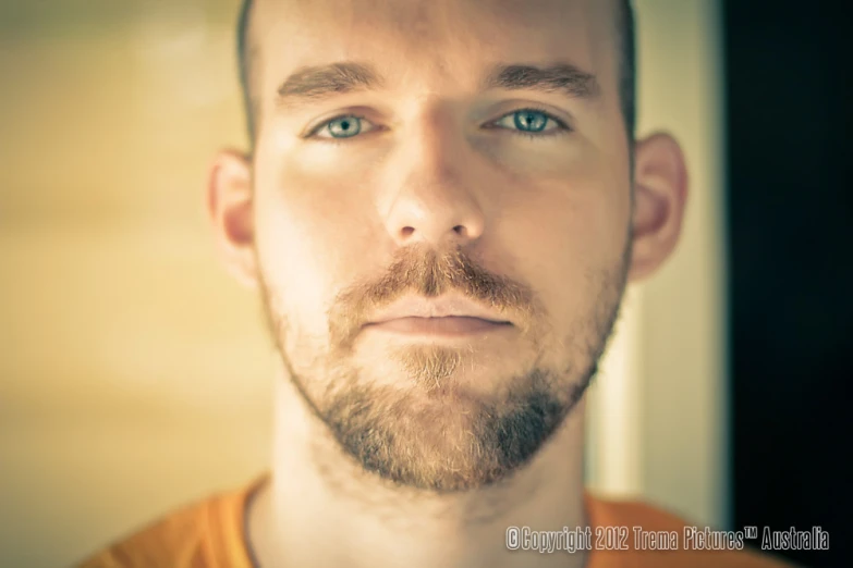 a man with a beard and a goatee looks into the camera