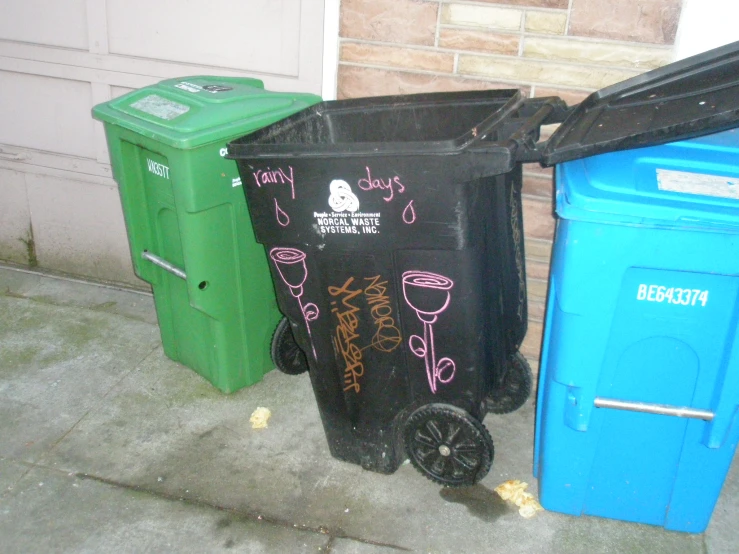 three trash cans sitting in front of a building