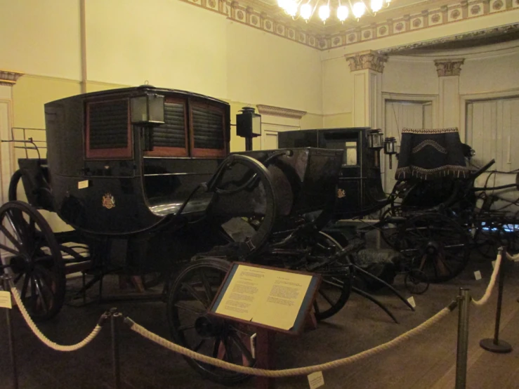 an exhibit of historical cars inside of a museum