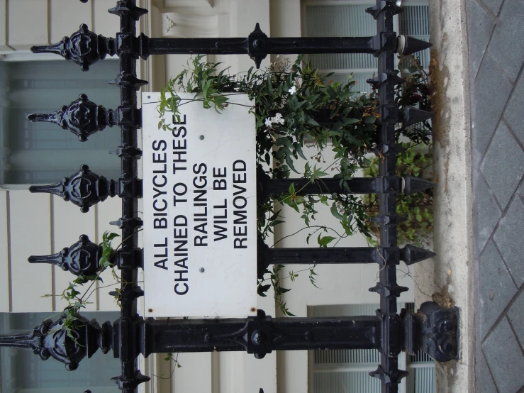 there is a sign outside that is covered with plants