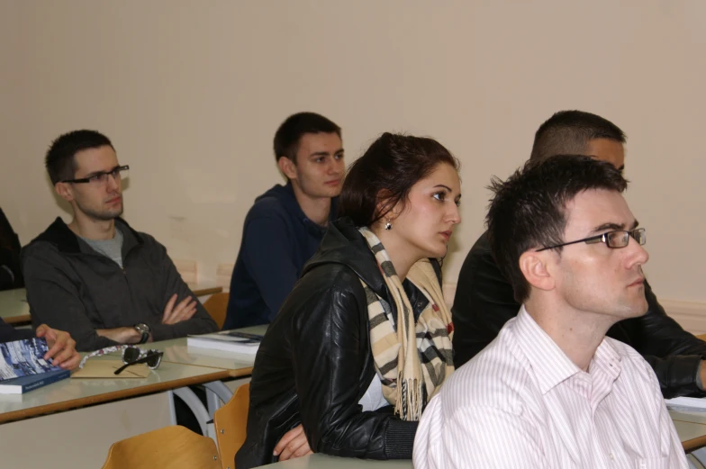 a group of people in a classroom listening to someone else