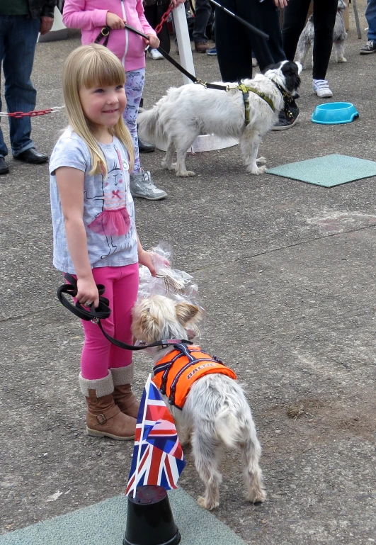 two children standing next to each other with small dogs