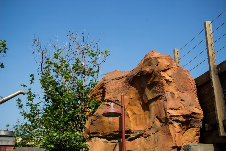 a large rock and a small lamppost are in the foreground