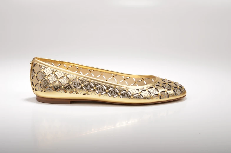 a golden flat ballerina shoe with silver detail