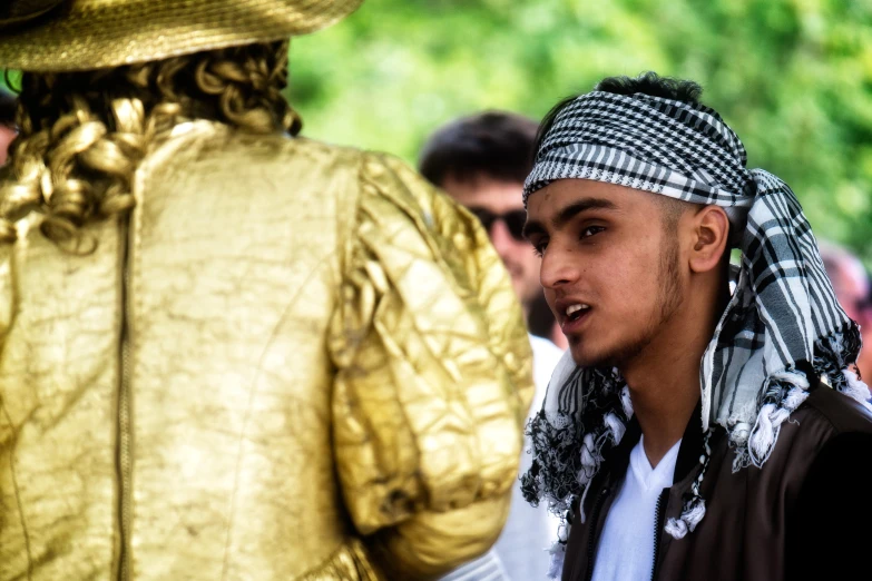 the statue of a person has been placed near a man wearing a hat