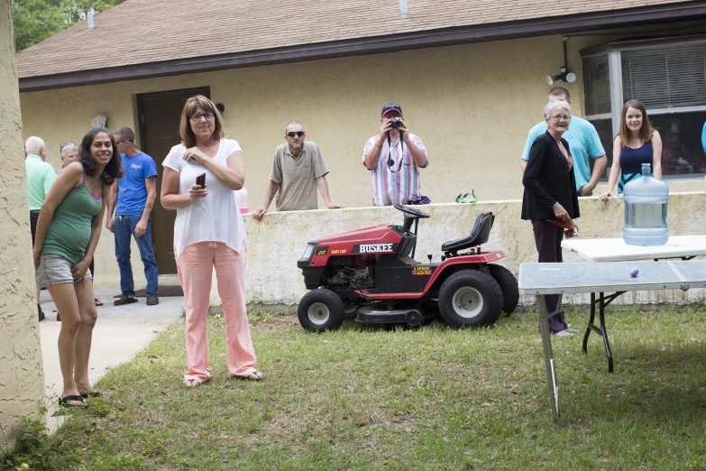 people stand around with some equipment near the lawn