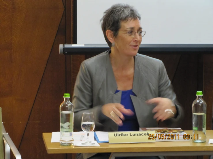 a woman sitting down talking into glasses at a conference