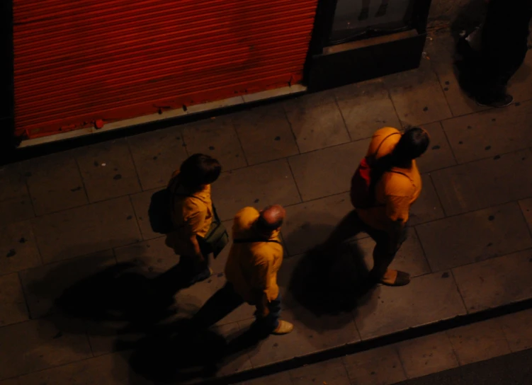 two people in fire suits are walking down a sidewalk