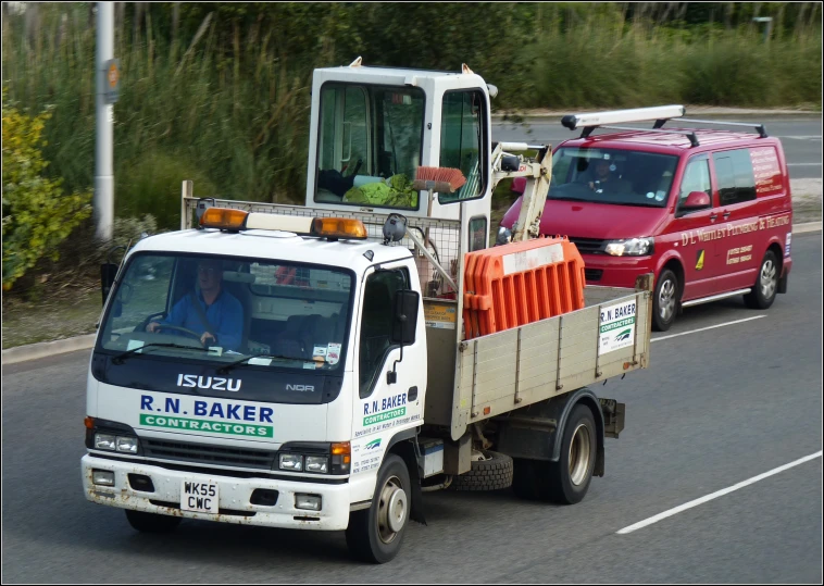 the two trucks are traveling next to each other on the road