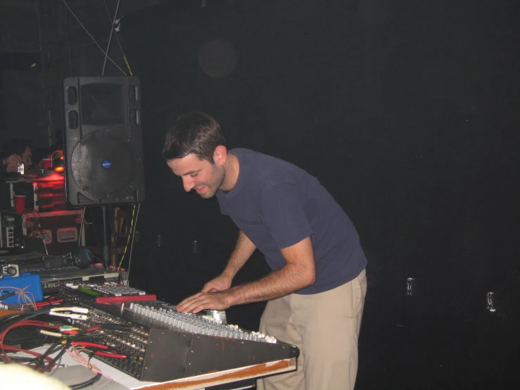 man in blue shirt making dj mixes on turntable