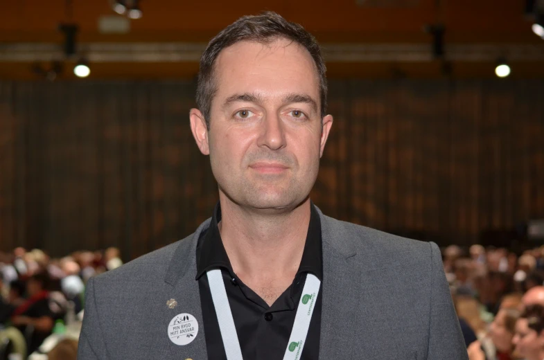 a man wearing a silver and black medal around his neck