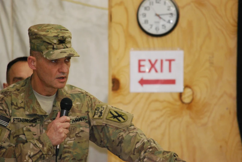 an army soldier giving a speech in front of a group