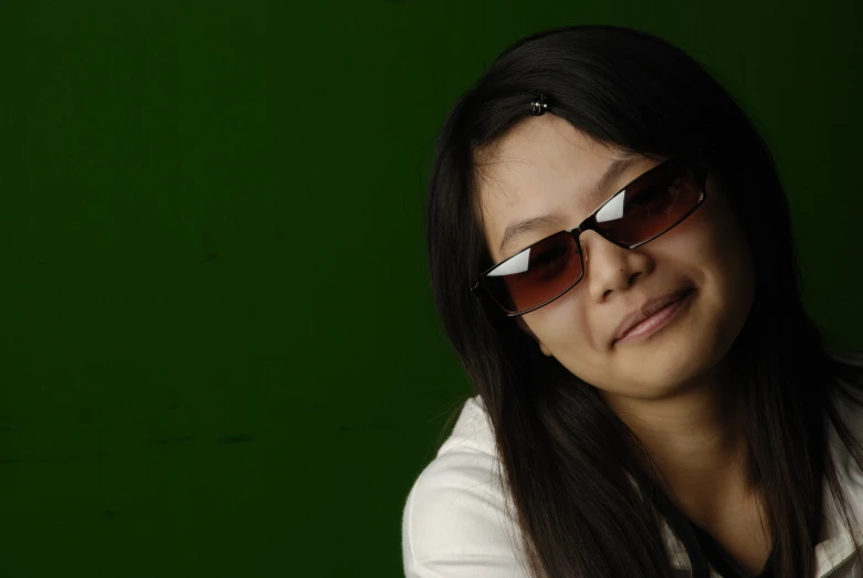 a woman with sun glasses is smiling and posing for the camera