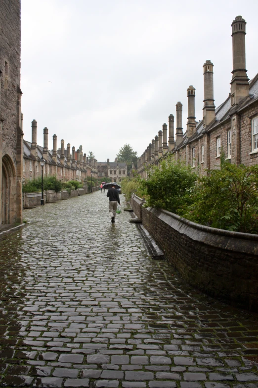 a person is walking down an old stone street