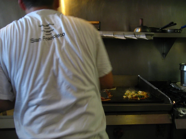 the man is preparing food in his kitchen