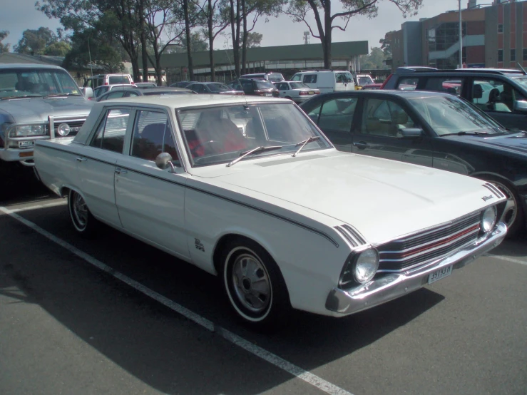 an old white station wagon is parked in a parking lot