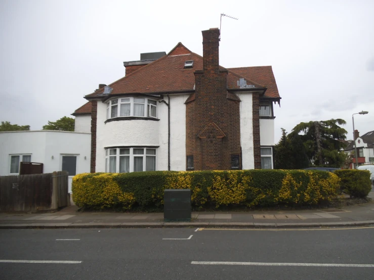 a white house with red roof and brown roof