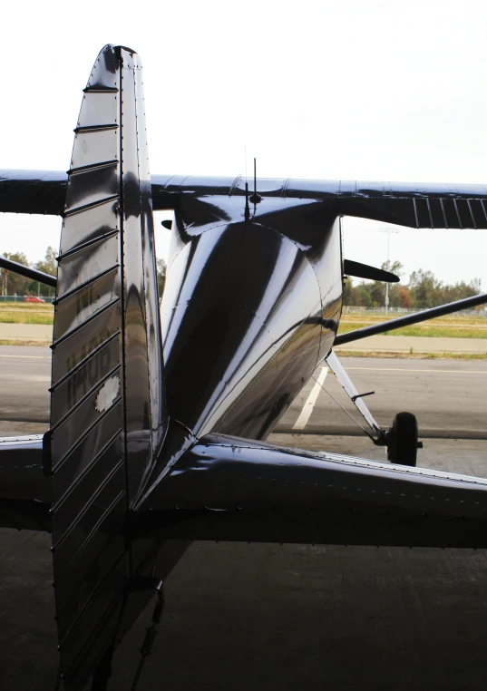 the tail section of a silver plane parked at an airport