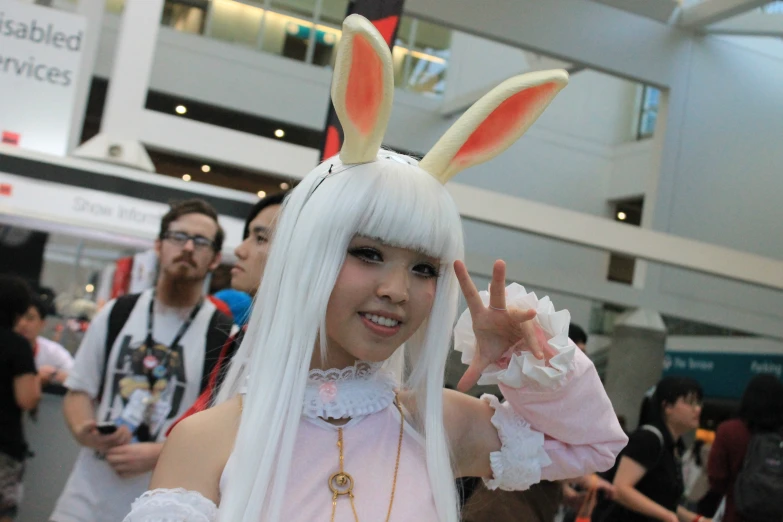 girl wearing bunny ears with white hair and holding up the peace sign