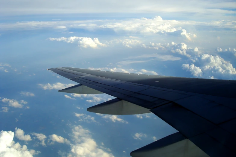 view from an airplane wing looking over the clouds