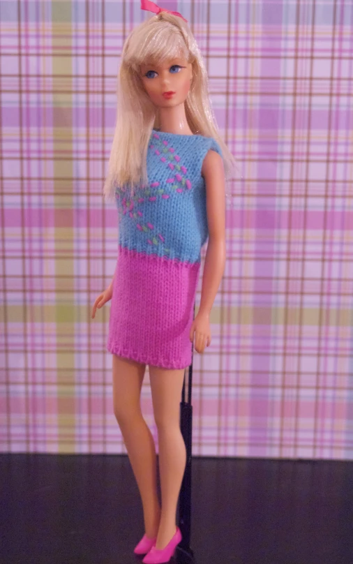 a barbie doll is standing on the floor with a purse