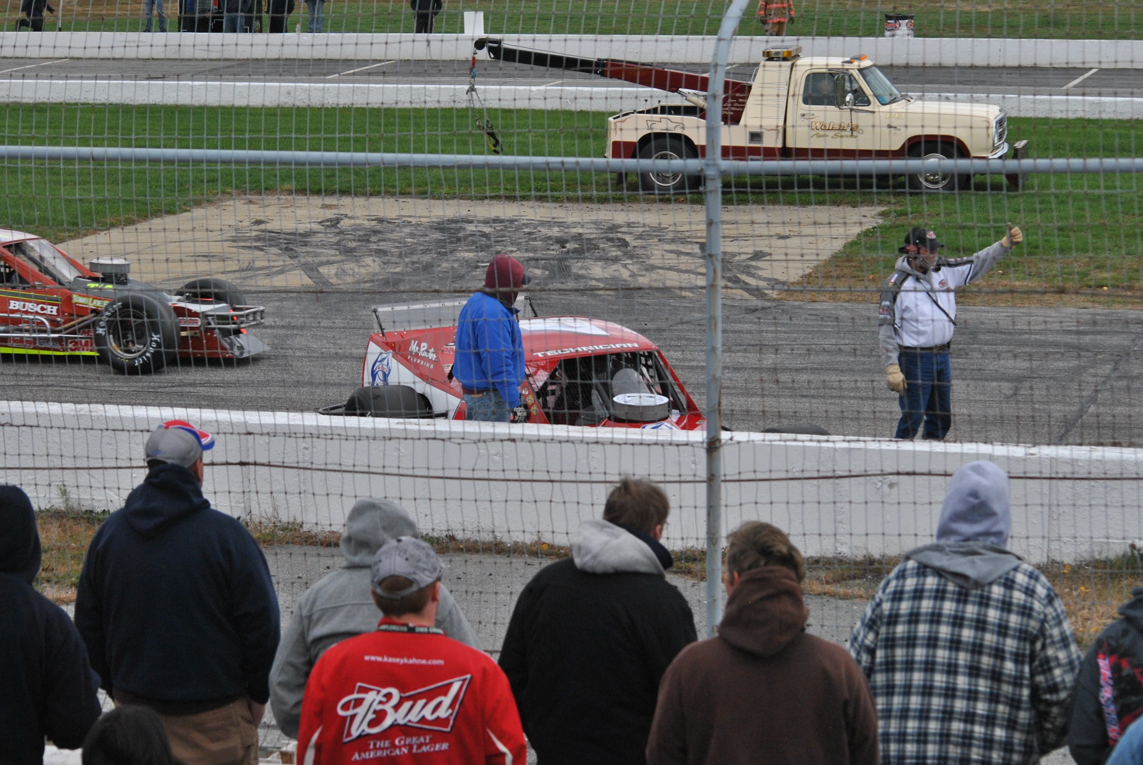 people watching cars race on a track next to each other