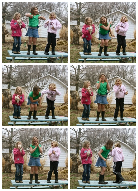 several little girls in different outfits stand on a wooden platform