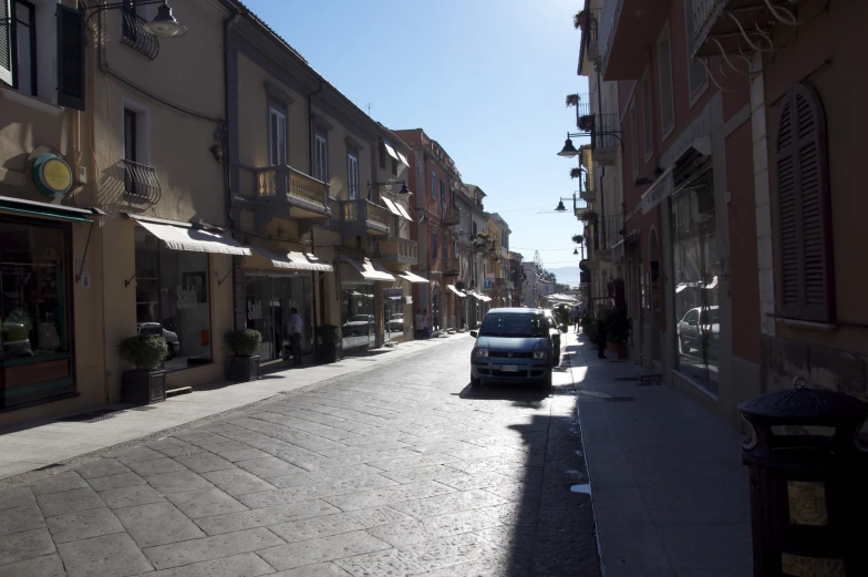 a car driving down a street between buildings