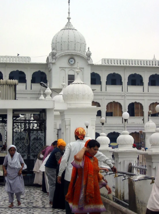 a group of people walk up to a building in india